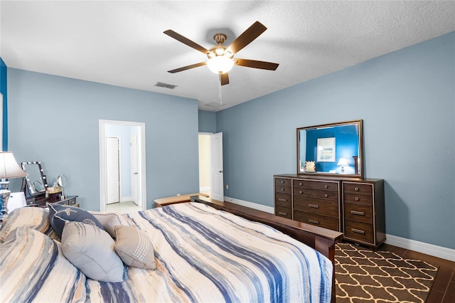bedroom featuring baseboards, visible vents, ceiling fan, and a textured ceiling