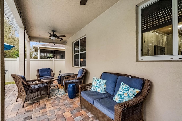 view of patio / terrace with fence, an outdoor hangout area, and a ceiling fan