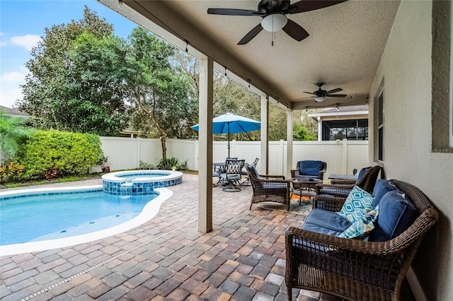 view of swimming pool featuring a patio area, a fenced backyard, a pool with connected hot tub, and outdoor lounge area