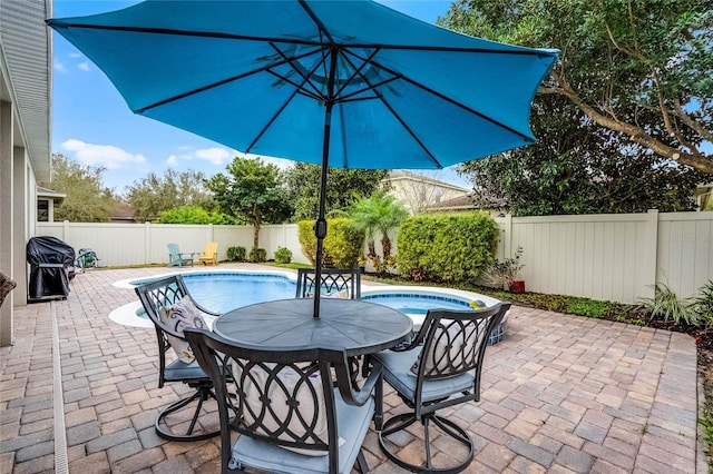 view of pool featuring a patio, outdoor dining space, and a fenced backyard