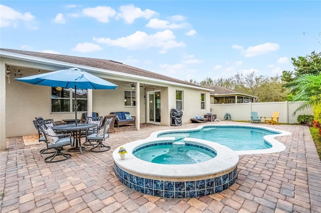 view of pool with a pool with connected hot tub, a fenced backyard, and a patio