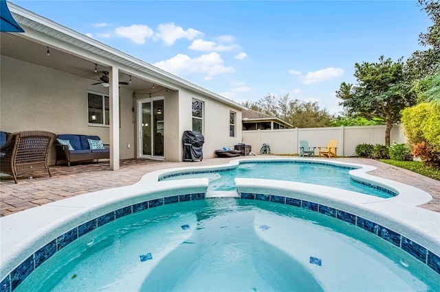view of swimming pool featuring a patio, a pool with connected hot tub, a grill, ceiling fan, and a fenced backyard