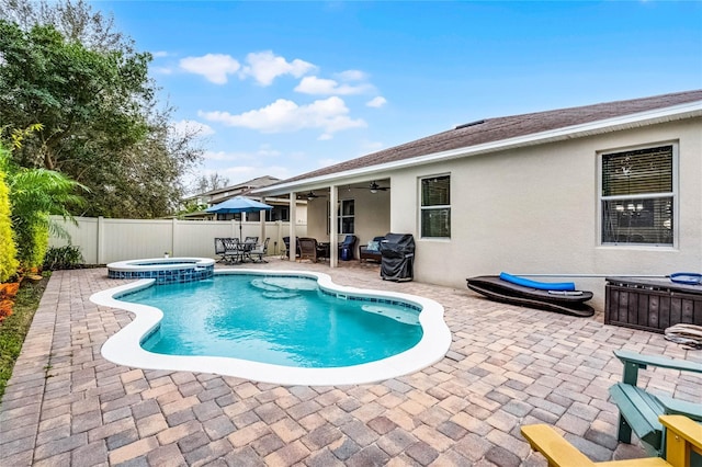 view of swimming pool featuring a pool with connected hot tub, area for grilling, a patio area, ceiling fan, and a fenced backyard
