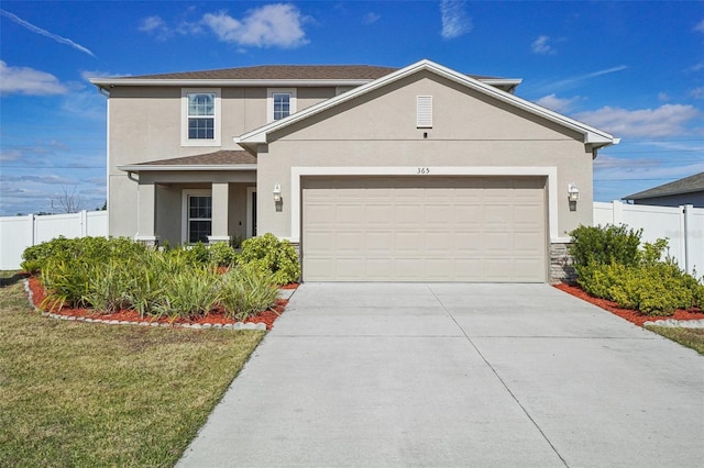 traditional-style home featuring driveway, an attached garage, fence, a front lawn, and stucco siding