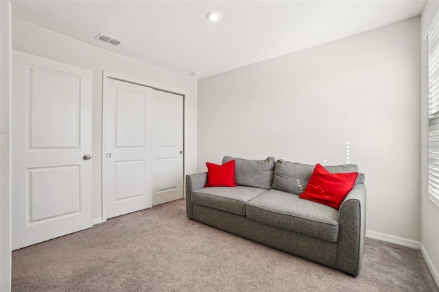 living area with carpet, visible vents, and baseboards