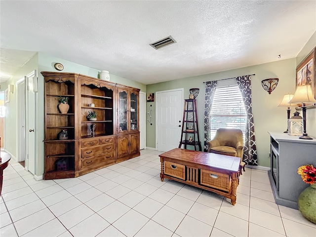 interior space featuring light tile patterned floors and a textured ceiling