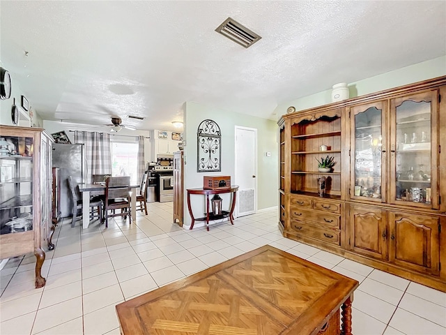 tiled dining space featuring ceiling fan and a textured ceiling