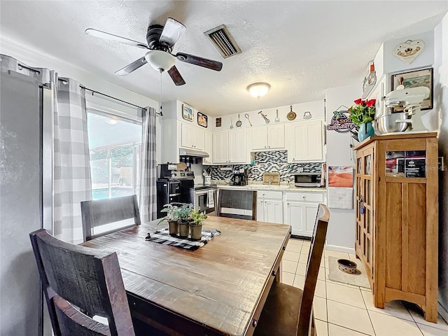 dining area with a textured ceiling, ceiling fan, and light tile patterned floors