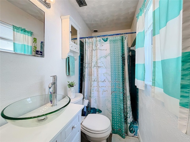 bathroom with plenty of natural light, vanity, and toilet