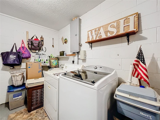 laundry room featuring washer and dryer, electric panel, and a textured ceiling