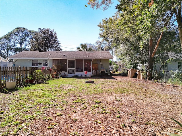 rear view of house featuring a yard and a sunroom