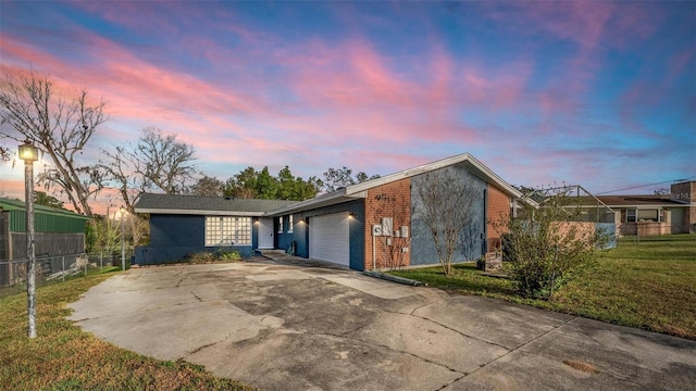 mid-century inspired home featuring a garage, brick siding, fence, driveway, and a front lawn