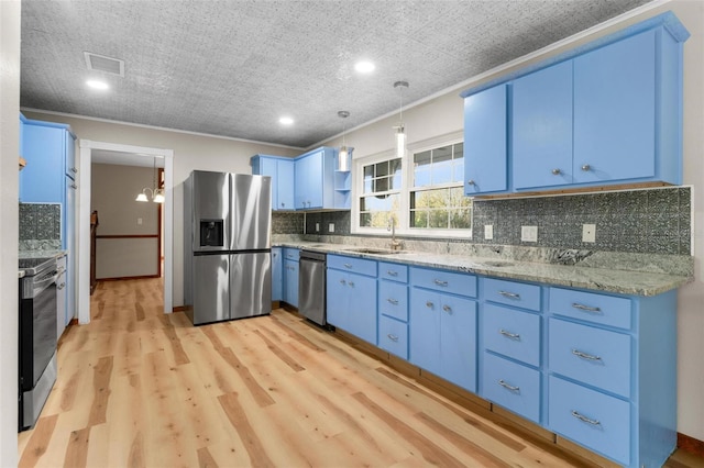 kitchen featuring blue cabinetry, appliances with stainless steel finishes, light wood-style floors, and a sink