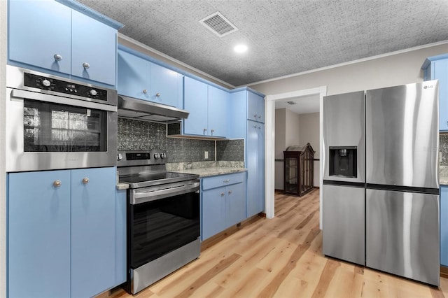 kitchen with stainless steel appliances, under cabinet range hood, visible vents, and blue cabinets