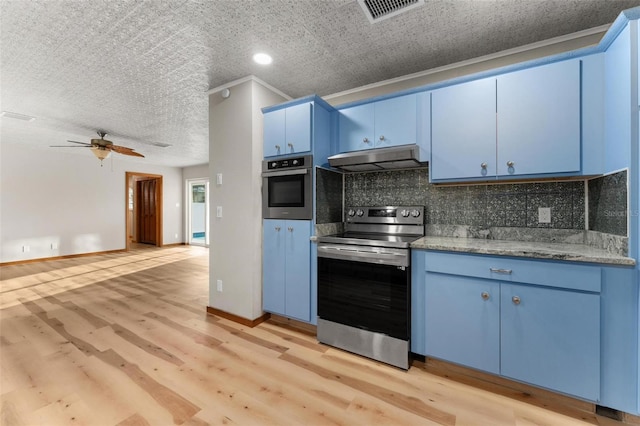 kitchen with blue cabinetry, under cabinet range hood, appliances with stainless steel finishes, and decorative backsplash