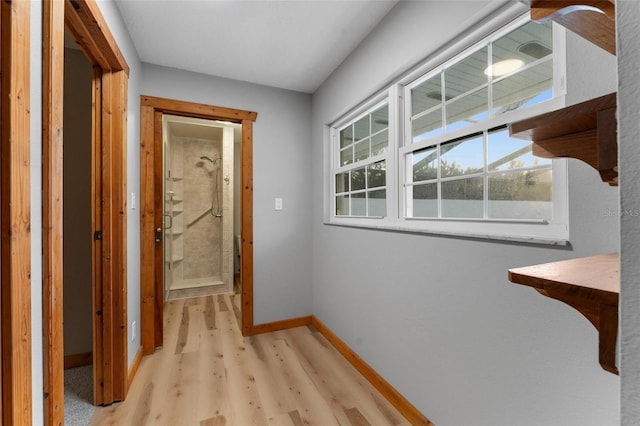 hall with baseboards and wood finished floors