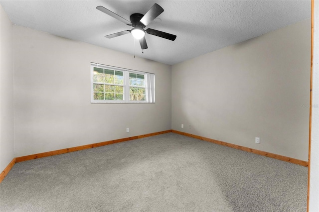 carpeted empty room featuring ceiling fan, a textured ceiling, and baseboards