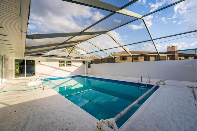 outdoor pool with glass enclosure and a patio area