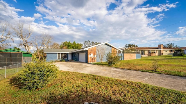 ranch-style house with a front lawn, concrete driveway, fence, and an attached garage