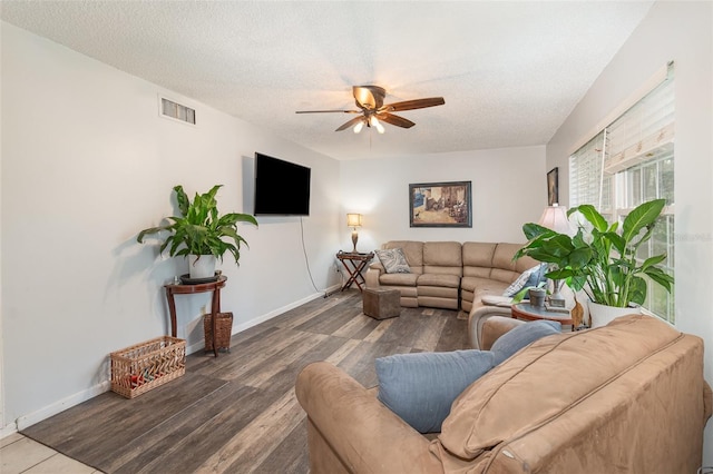 living area with baseboards, visible vents, a ceiling fan, wood finished floors, and a textured ceiling