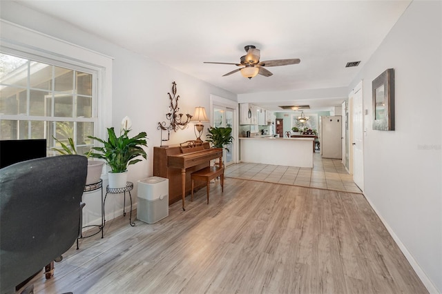 office area featuring baseboards, a ceiling fan, visible vents, and light wood-style floors