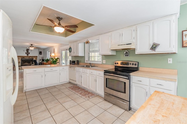 kitchen featuring white appliances, a raised ceiling, white cabinets, and under cabinet range hood