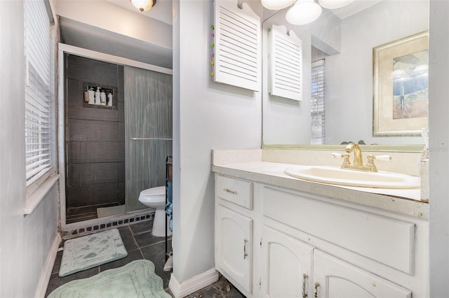 bathroom featuring a stall shower, vanity, toilet, and baseboards