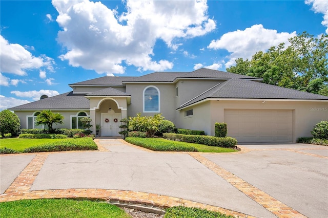 mediterranean / spanish-style house featuring driveway, a garage, and stucco siding