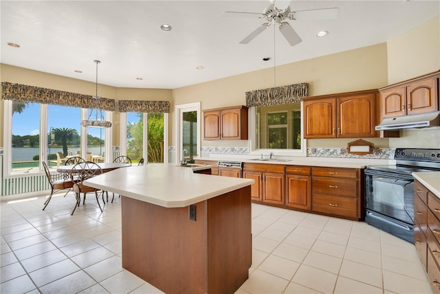 kitchen with light countertops, hanging light fixtures, black range with electric cooktop, and under cabinet range hood