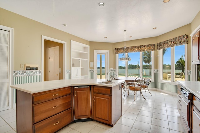 kitchen featuring a kitchen island with sink, pendant lighting, and light countertops