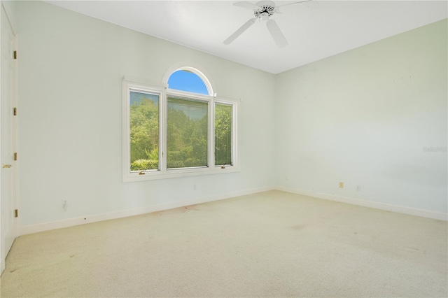 empty room with light carpet, ceiling fan, and baseboards