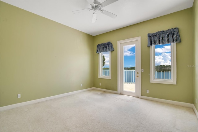 unfurnished room with ceiling fan, baseboards, and light colored carpet