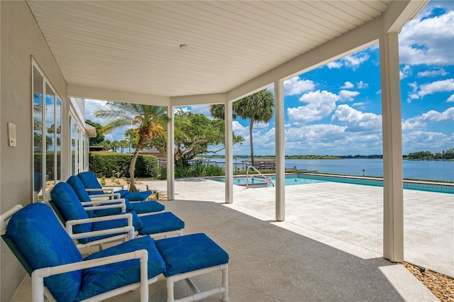 view of patio / terrace featuring a water view and a fenced in pool