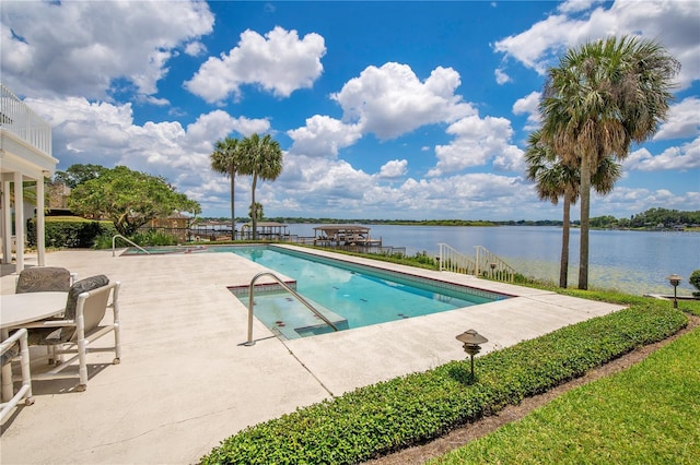 community pool with a water view and a patio area