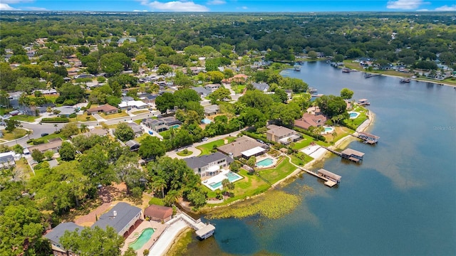 drone / aerial view featuring a water view, a residential view, and a wooded view