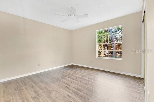 unfurnished room featuring light wood-style floors, ceiling fan, and baseboards