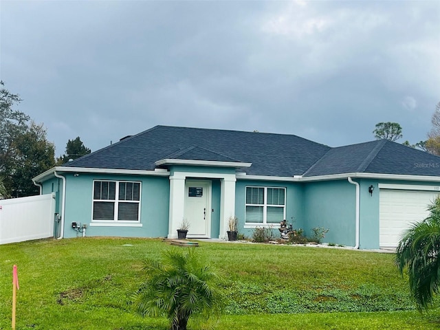 view of front of home with a garage and a front lawn