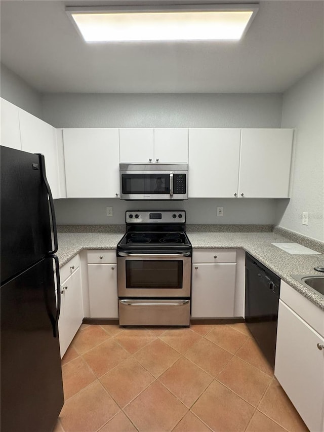 kitchen with white cabinetry, black appliances, and light tile patterned flooring