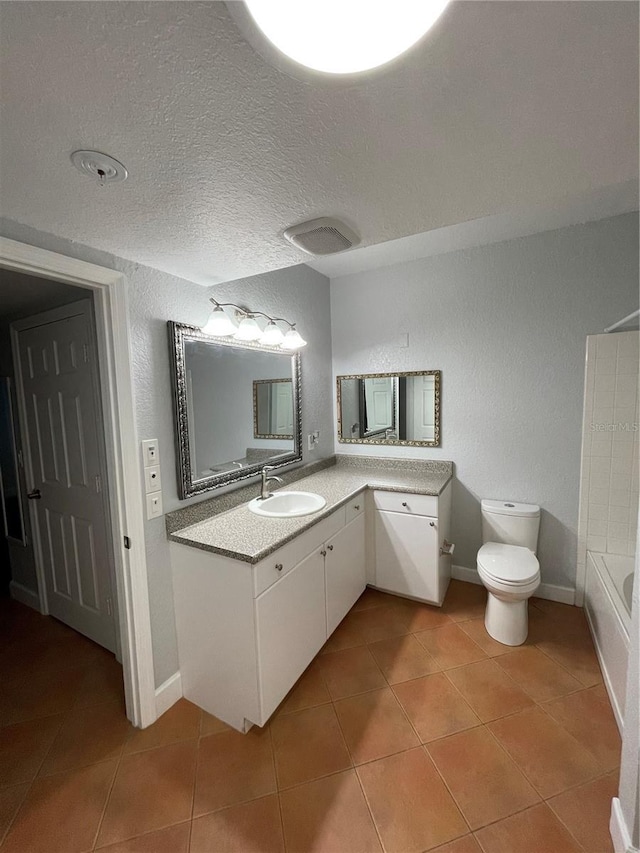 bathroom with vanity, tile patterned flooring, a textured ceiling, and toilet