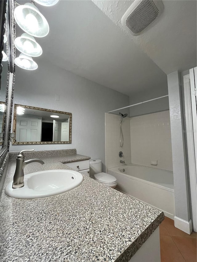 full bathroom with tiled shower / bath, tile patterned floors, toilet, and vanity