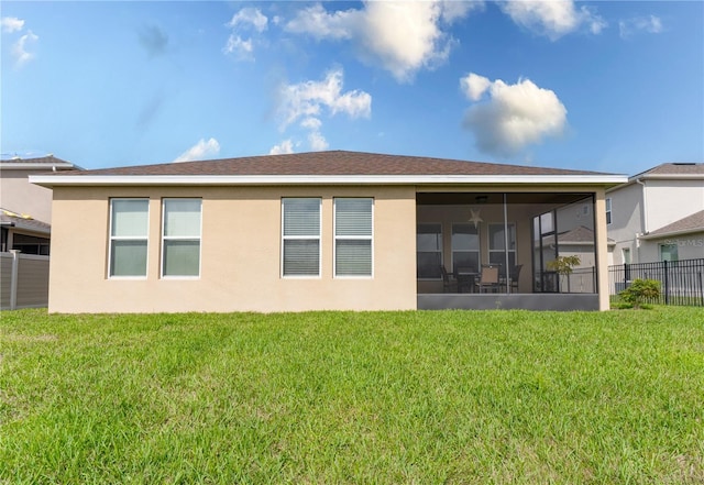 rear view of property featuring a lawn and a sunroom