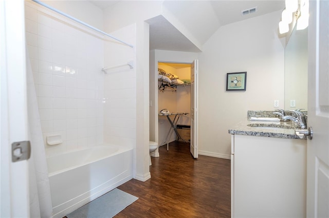 full bathroom featuring toilet, vaulted ceiling, vanity, shower / washtub combination, and hardwood / wood-style floors