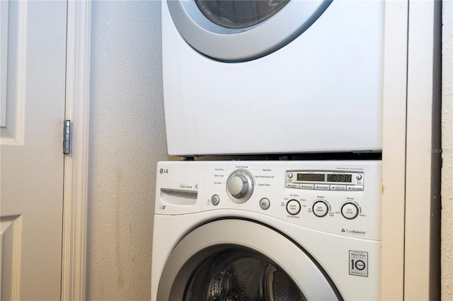 washroom featuring stacked washer / drying machine