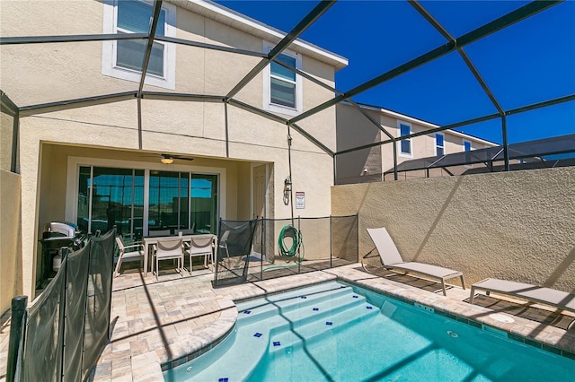 view of swimming pool featuring ceiling fan, a patio, and glass enclosure