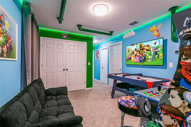 rec room featuring a textured ceiling and light colored carpet