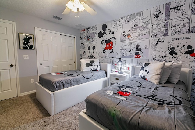 bedroom with ceiling fan, carpet floors, a textured ceiling, and a closet