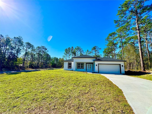 view of front of house featuring a garage, driveway, a front yard, and stucco siding