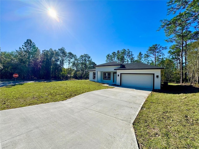 view of front of home with a garage, driveway, a front lawn, and stucco siding