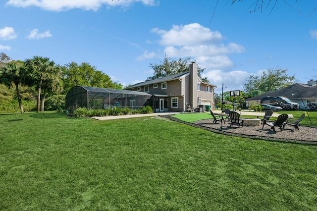 view of yard featuring an outdoor fire pit, glass enclosure, and a patio