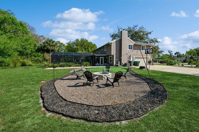 view of home's community with an outdoor fire pit and a lawn